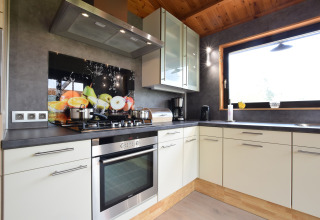 Moderne keuken in lodge Famenne te België, met een groot raam, fruitdecoratie en stijlvolle uitstraling.