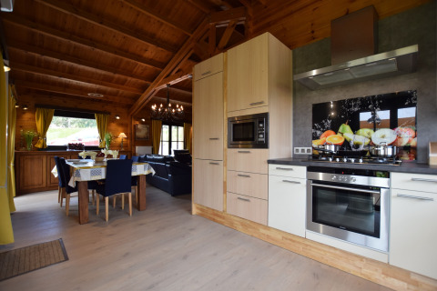 Moderne keuken en eetkamer met veel hout en licht in lodge Famenne, gelegen in België.