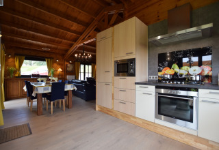 Moderne keuken en eetkamer met veel hout en licht in lodge Famenne, gelegen in België.