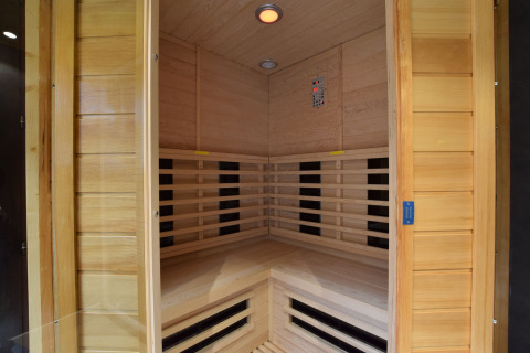 Binnenzicht van een moderne infraroodsauna met houten wanden in de lodge Famenne in België.