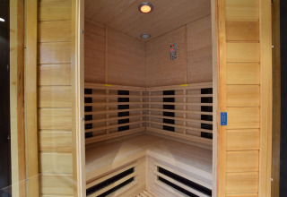 Binnenzicht van een moderne infraroodsauna met houten wanden in de lodge Famenne in België.