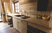 Cucina moderna in legno con ampia finestra nella casa sull'albero Bird Nest, Belgio, atmosfera accogliente.