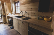 Cucina moderna in legno con ampia finestra nella casa sull'albero Bird Nest, Belgio, atmosfera accogliente.