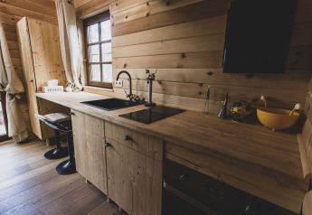 Cucina moderna in legno con ampia finestra nella casa sull'albero Bird Nest, Belgio, atmosfera accogliente.