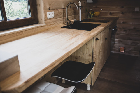 Cucina moderna in casa sull'albero 'Bird Nest' in Belgio, con piano in legno e lavello nero.