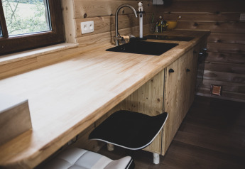 Cucina moderna in casa sull'albero 'Bird Nest' in Belgio, con piano in legno e lavello nero.