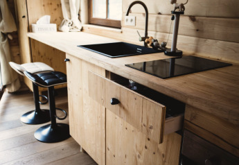 Cucina moderna nella casa sull'albero Bird Nest in Belgio con lavello nero e mobili in legno.