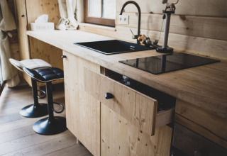 Cucina moderna nella casa sull'albero Bird Nest in Belgio con lavello nero e mobili in legno.