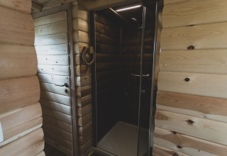 Modern glass shower cabin in wooden interior, photographed at the Bird Nest tree house in Belgium.