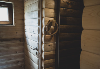 Interno della casa sull'albero Bird Nest in Belgio con pareti in legno rustico, porta e finestra.