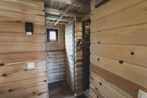 Interior view of the 'Bird Nest' tree house in Belgium featuring light wooden walls and a small window.