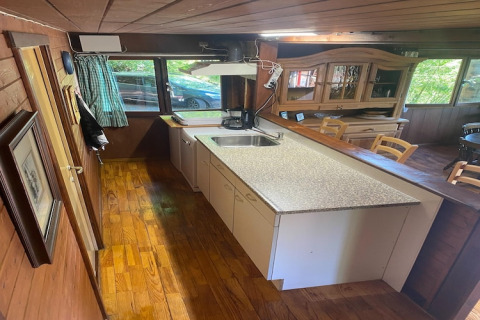 Keuken in chalet 'La Bressine' in België, met houten interieur, aanrecht en eethoek.