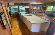 Keuken van chalet 'La Bressine' in België, met houten afwerking en zicht op het eetgedeelte.