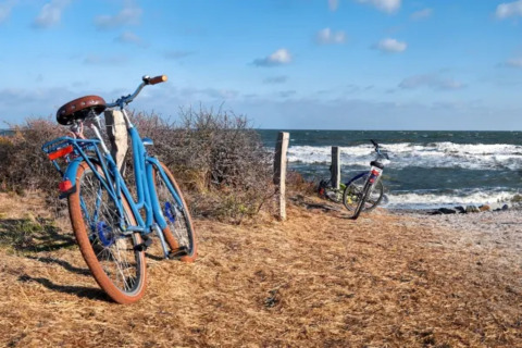 Dos bicicletas aparcadas junto al mar en el Resort «Beachside 5» en Bélgica, el cielo está azul.