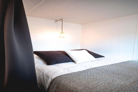 Interior de una tienda safari en Resort Beachside 5, Bélgica, con cama cómoda y luz ambiental cálida.