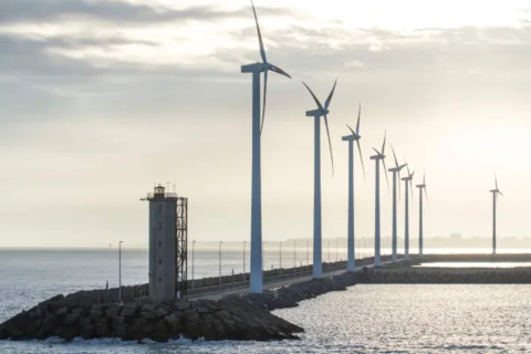Aerogeneradores alineados cerca del mar en Bélgica vistos desde el Resort «Beachside 5» con faro y costa