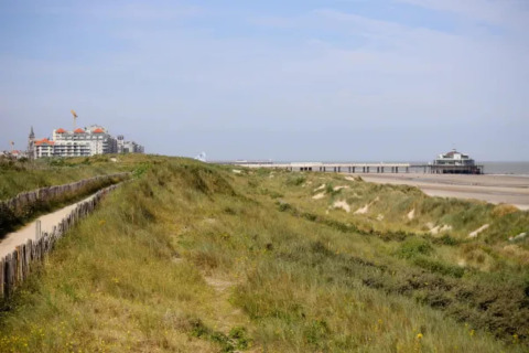 Vista de dunas de arena, playa y un muelle en la costa junto al Resort Beachside 5 en Bélgica.