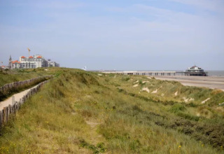 Vista de dunas de arena, playa y un muelle en la costa junto al Resort Beachside 5 en Bélgica.