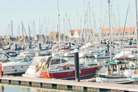 Barcos atracados en un puerto deportivo cerca del Resort «Beachside 5» en Bélgica bajo cielos despejados.
