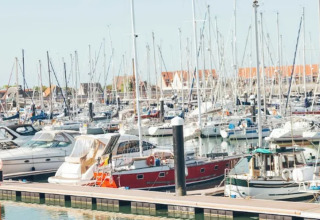 Barcos atracados en un puerto deportivo cerca del Resort «Beachside 5» en Bélgica bajo cielos despejados.