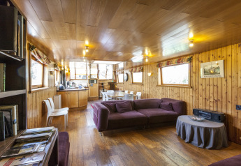 Vista interna della houseboat St Antoine Isera in Belgio con pannelli in legno e arredamento moderno.