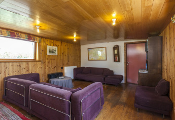 Soggiorno nella casa galleggiante St Antoine Isera in Belgio con pareti in legno e divani viola.