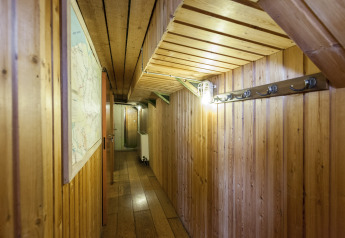 Corridoio rivestito in legno sulla houseboat 'St Antoine Isera' in Belgio con ganci e una mappa a muro.