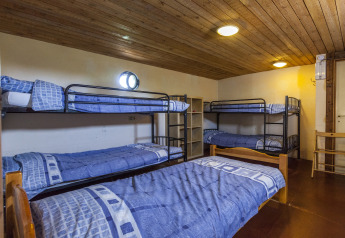 Dormitorio con letti a castello e letto singolo sulla houseboat St Antoine Isera in Belgio, biancheria blu.
