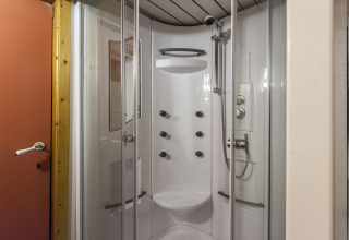 Moderne brusekabine med flere brusere og glasdøre på husbåden St Antoine Isera i Belgien.