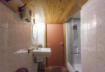 Bagno sulla houseboat St Antoine Isera in Belgio, con soffitto in legno, doccia e lavabo.