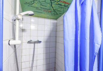 Doccia con tenda blu sulla casa galleggiante St Antoine Isera in Belgio, mappa decorata sul soffitto.