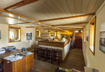 Vista interna della houseboat St Antoine Isera in Belgio con area bar, scrivania e arredo in legno.