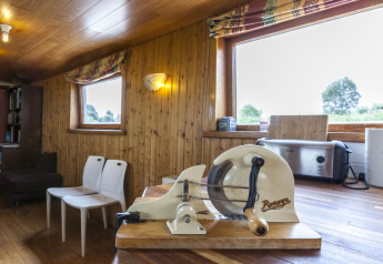 Vista interna della houseboat 'St Antoine Isera' in Belgio con affettapane vintage sul tavolo.