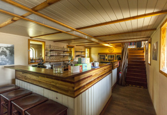 Vista interna del bar della houseboat St Antoine Isera in Belgio, con finiture in legno chiaro.
