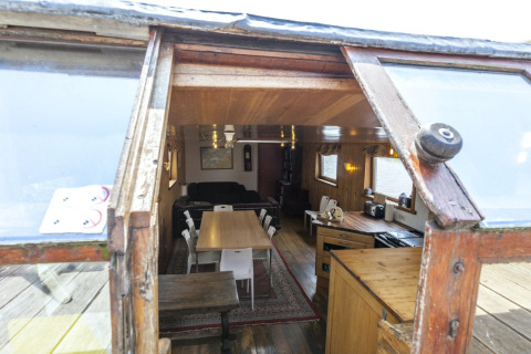 Blick ins Wohnzimmer und die Küche des Hausboots St Antoine in Belgien durch offene Türen.