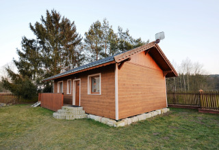 Esterno dello chalet «Marcela» in Repubblica Ceca, recintato e circondato da alberi in un ambiente tranquillo.