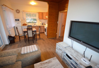 Soggiorno e cucina dello chalet Marcela in Repubblica Ceca con tavolo da pranzo, divano e TV.