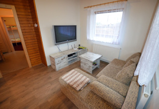 Soggiorno accogliente nello chalet Marcela in Repubblica Ceca con divano, TV e tavolino.