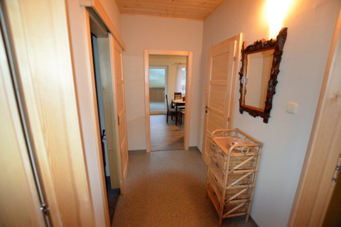 Corridoio dello chalet Marcela in Repubblica Ceca con cassetti in vimini e specchio decorativo a parete.