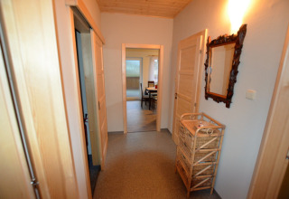 Corridoio dello chalet Marcela in Repubblica Ceca con cassetti in vimini e specchio decorativo a parete.