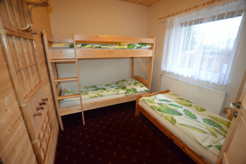 Camera da letto nello chalet 'Marcela' in Repubblica Ceca con letto a castello e singolo, interni in legno.