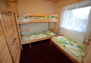 Camera da letto nello chalet 'Marcela' in Repubblica Ceca con letto a castello e singolo, interni in legno.