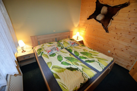 Camera accogliente presso lo chalet Marcela, Repubblica Ceca, con letto matrimoniale e decorazioni in legno.
