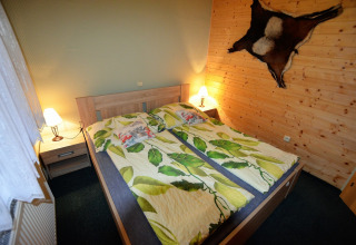 Camera accogliente presso lo chalet Marcela, Repubblica Ceca, con letto matrimoniale e decorazioni in legno.