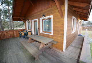 Terrazza in legno con tavolo da picnic presso lo chalet Marcela in Repubblica Ceca, circondata da natura.