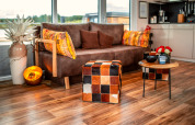 Modernes Wohnzimmer auf dem Houseboat am Bärwalder See mit braunem Sofa und farbenfroher Einrichtung.