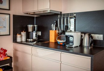 Moderne Küchenzeile mit Kaffeemaschine, Wasserkocher, Heißluftfritteuse und Küchenutensilien im Houseboat am Bärwalder See.
