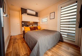 Modernes Schlafzimmer im Houseboat am Bärwalder See mit Doppelbett, Holzboden und stilvoller Einrichtung.