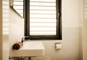 Modernes Badezimmer auf der Houseboat am Bärwalder See mit Waschbecken, Fenster und Handtuch.
