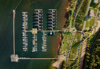 Vista aérea del puerto en Houseboat am Bärwalder See, con barcos atracados y vegetación junto al lago